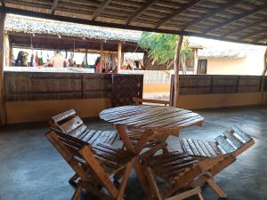 2 sedie e un tavolo in legno in un patio di El Kachi Hospedaje y Restaurante a Uribia