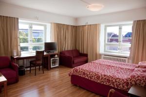 a bedroom with a bed and a desk and a tv at Hotel Anna in Helsinki