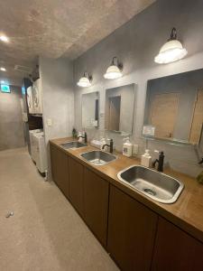 a bathroom with two sinks and two mirrors at Nawate Guesthouse in Matsumoto