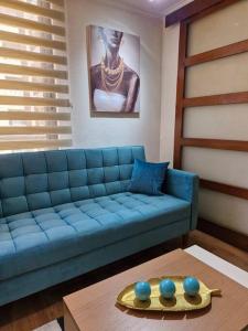 a living room with a blue couch and a table at Barrio Bellas Artes in Santiago