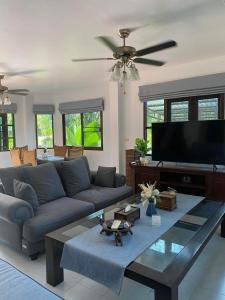 a living room with a couch and a flat screen tv at Bann Jai Dee in Nai Yang Beach