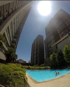 a swimming pool in a city with tall buildings at departamentos santiago centro moneda SUAGON APART HOTEL in Santiago