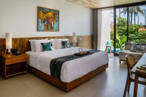 a bedroom with a large bed with a table and a couch at Langit Pitu Villas in Ketewel
