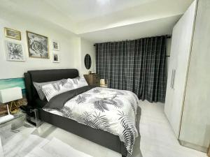 um quarto com uma cama em preto e branco e uma janela em Tropez 1br City Light View em Manila