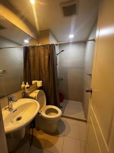 uma casa de banho com um WC, um lavatório e um chuveiro em Tropez 1br City Light View em Manila