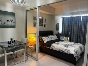 um quarto com uma cama, uma mesa e uma secretária em Tropez 1br City Light View em Manila