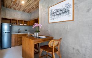 una cucina con tavolo in legno e frigorifero di Langit Pitu Villas a Ketewel