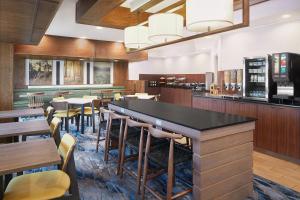 a restaurant with a bar and tables and chairs at Fairfield Inn Huntsville in Huntsville