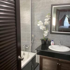 La salle de bains est pourvue d'un lavabo, d'un miroir et d'une baignoire. dans l'établissement Bann Jai Dee, à Nai Yang Beach