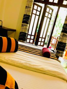 a bed with two pillows on it in a room with windows at Green Horizon Ella in Ella