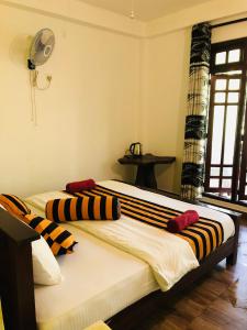 a bedroom with two beds with striped pillows on them at Green Horizon Ella in Ella