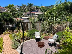 a garden with two chairs and a brick patio at The Boshoff in Durban