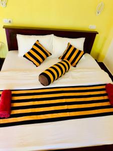 a bed with black and white striped pillows on it at Green Horizon Ella in Ella