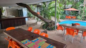 eine Terrasse mit Tischen und Stühlen und einem Pool in der Unterkunft R A GUEST HOUSE PEMBA in Pemba
