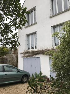 un coche verde estacionado frente a un edificio blanco en chambre double chez Catherine et Jean-Luc en Bretagne, en Audierne
