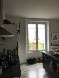 a kitchen with a large window in the corner at chambre double chez Catherine et Jean-Luc en Bretagne in Audierne