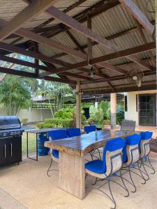 une grande table et des chaises en bois sous un pavillon dans l'établissement Bann Jai Dee, à Nai Yang Beach