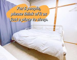 a bed in a room with a sign that reads for people please think at Akira&chacha杉並区世田谷direct to shinjuku for 13 min 上北沢4分 近涉谷新宿 in Tokyo