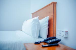 telefon na stole obok łóżka w obiekcie Teranga Lodge and Restaurant w mieście Ihumwa