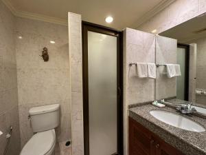 a bathroom with a toilet and a sink and a shower at Copa Hotel in Pattaya