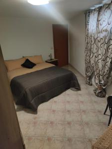 - une chambre avec un lit dans une chambre avec des rideaux dans l'établissement Casa Vacanze Margherita, à Ispica