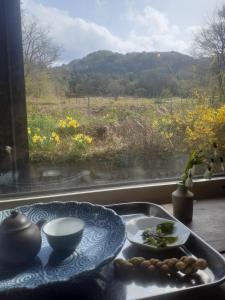 einen Tisch mit einem Teller Essen neben einem Fenster in der Unterkunft Tanehachi Farm Guesthouse - Vacation STAY 29709v in Aomori