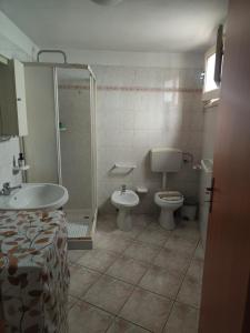 La salle de bains est pourvue d'un lavabo, de toilettes et d'une douche. dans l'établissement Casa Vacanze Margherita, à Ispica