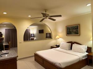 a bedroom with a bed and a ceiling fan at Copa Hotel in Pattaya