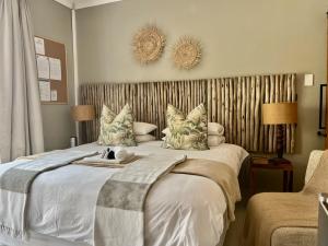 a bedroom with a large bed with white sheets and pillows at The Boshoff in Durban