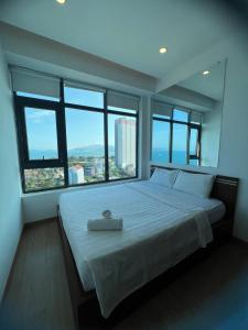 1 dormitorio con 1 cama grande y ventanas grandes en Sea Homes en Nha Trang