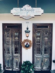 una casa con dos puertas y una señal en ella en The Dragonfly Guest House en Nueva Orleans