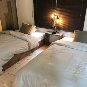 長野的住宿－Hoshinaya - Vacation STAY 45451v，一间卧室设有两张床和一扇带灯的窗户