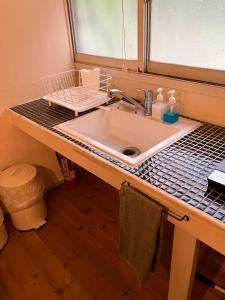eine Badezimmertheke mit einem Waschbecken und einem Fenster in der Unterkunft Hoshinaya - Vacation STAY 45451v in Nagano