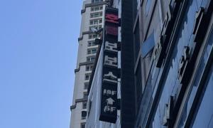華城市的住宿－Dongtan BobosHotel，一座高大的建筑,旁边有一个标志