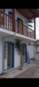 ein kleines Haus mit einem Balkon und einer Tür in der Unterkunft Pousada Flores da Terra in Paraty