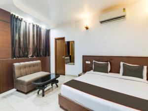 a hotel room with a bed and a chair at Collection O Hotel diamond plaza in Sītāpur