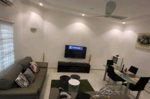 Il comprend un salon doté d'un canapé et d'une télévision à écran plat. dans l'établissement Entrée personnelle fidjrossè, à Cotonou