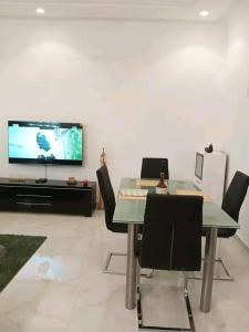 - une salle à manger avec une table, des chaises et une télévision dans l'établissement Entrée personnelle fidjrossè, à Cotonou