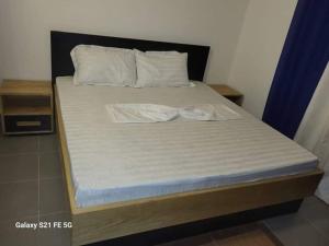 - un lit avec des draps et des oreillers blancs dans l'établissement Entrée personnelle fidjrossè, à Cotonou
