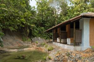 a small building next to a body of water at Sama Kosgoda - A Santani Retreat in Kosgoda