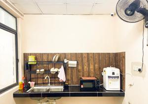 cocina con fregadero y microondas en HOSTEL MA ROOMSTAY - Airport Transit KLIA 1 KLIA 2, en Sepang