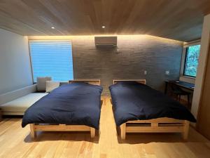 2 Betten mit Kissen in einem Zimmer mit einer Wand in der Unterkunft Mizuho Highland - Camp - Vacation STAY 42325v 