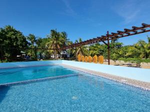 a swimming pool at a resort with chairs and trees at Yemaya de Laiya powered by Cocotel in Biga