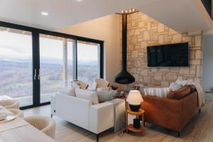 a living room with a couch and a tv at Hilltop Cabin in Munteni