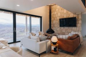 a living room with a couch and a tv at Hilltop Munteni in Munteni