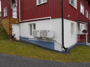 a building with two air conditioners on the side of it at Perniön majoitus alakerta in Perniö