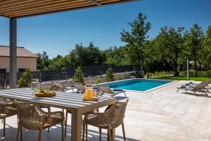 a patio with a table and chairs and a pool at Villa Gala by Rent Istria in Kringa
