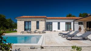 a patio with lounge chairs and a swimming pool at Villa Gala by Rent Istria in Kringa