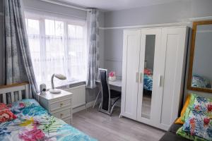 a bedroom with a bed and a desk and a mirror at Spacious Double Bedroom in Shooters Hill in London