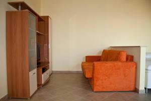 soggiorno con sedia arancione e armadio di Betulle 2F a Leinì